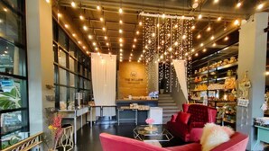 A modern interior with a red sofa, a staircase, and a wall with shelves. - The Willow Phangan (Ko Pha-ngan)