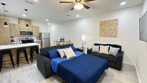 A modern apartment with a kitchenette, a dining area, a living room with a sofa and a bed. - NEW Mcallen Apartament (Pharr)