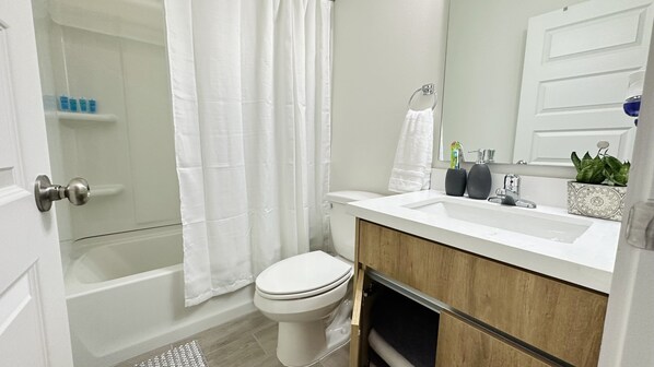 A bathroom with a bathtub, toilet, and sink. - NEW Mcallen Apartament (Pharr)
