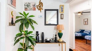 A living room with a sofa, a coffee table, and a large green plant. - The Georgia Peach (Forest Park)
