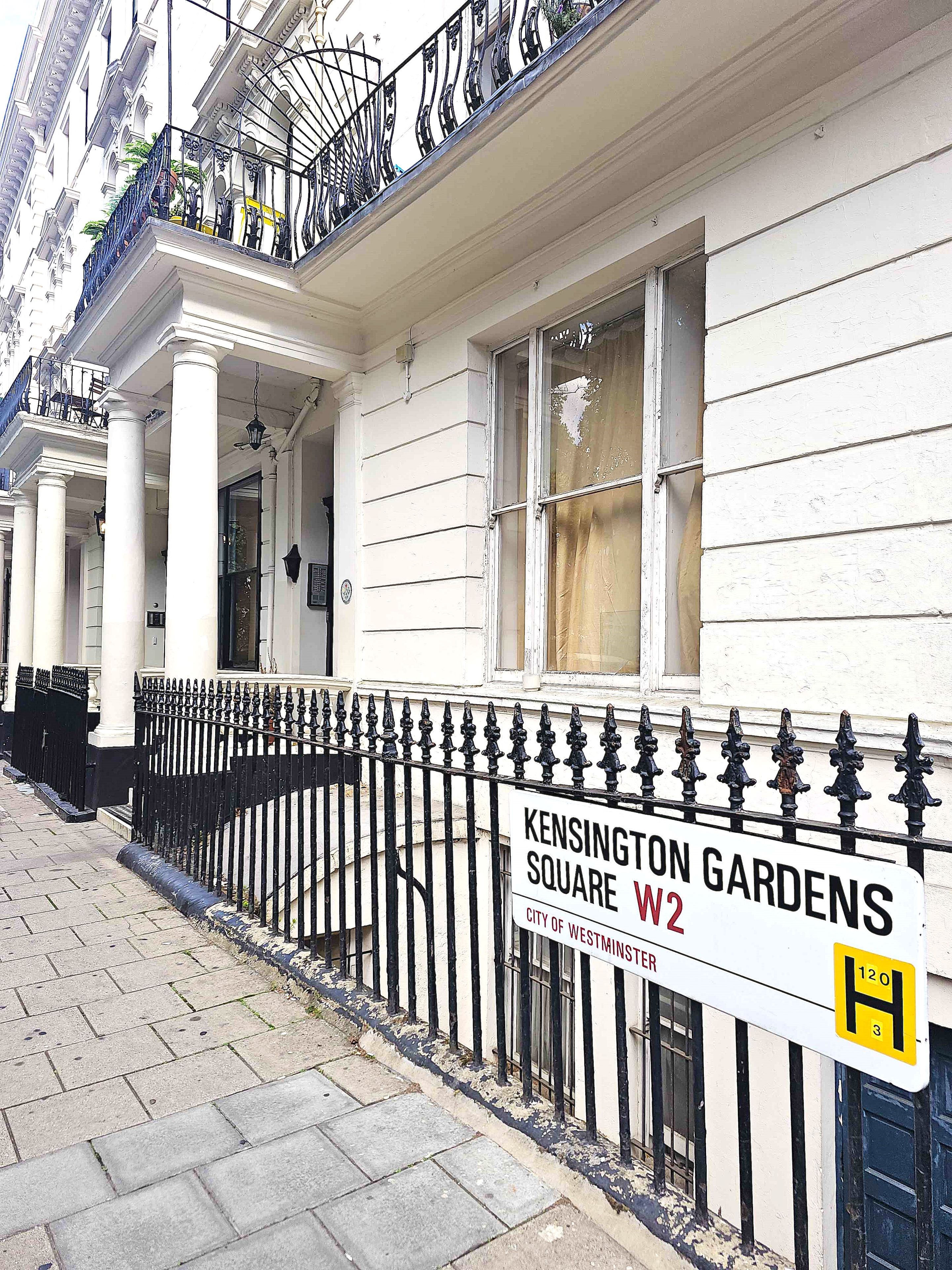 Un edificio con un letrero que dice 'Kensington Gardens W2', indicando su ubicación.