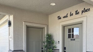 A building entrance with two doors, a potted plant, and a 'No Soliciting' sign. - New Built - Clean - Comfort (Grand Junction)