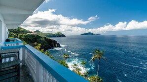 A balcony with a view of the ocean and distant islands.