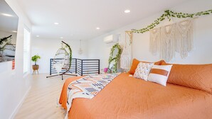 A bedroom with a large bed, a hanging chair, and macramé wall hangings. - Jacuzzi Hot Tub + Zion Base Camp @La Chona (Hurricane)