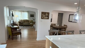 A modern kitchen with a marble countertop and wooden cabinets. - Spacious & Charming Home  (Portland)