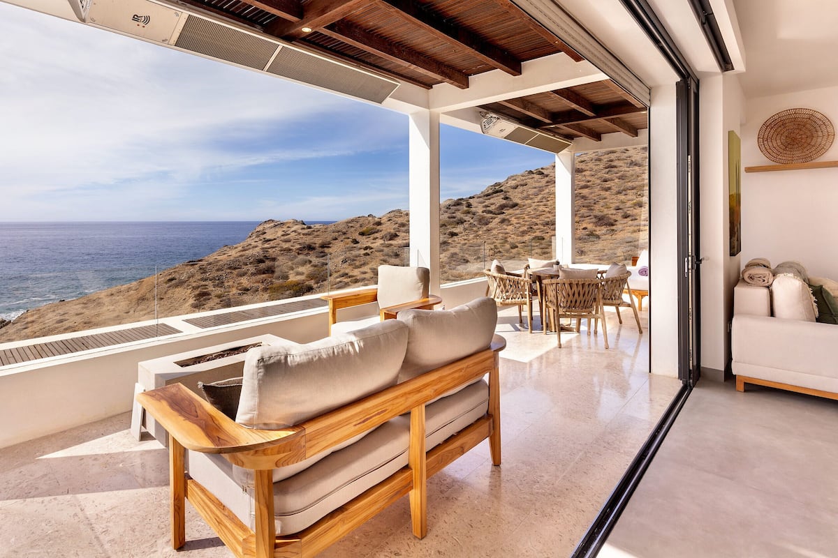 A modern living room with a large window overlooking a coastal landscape.