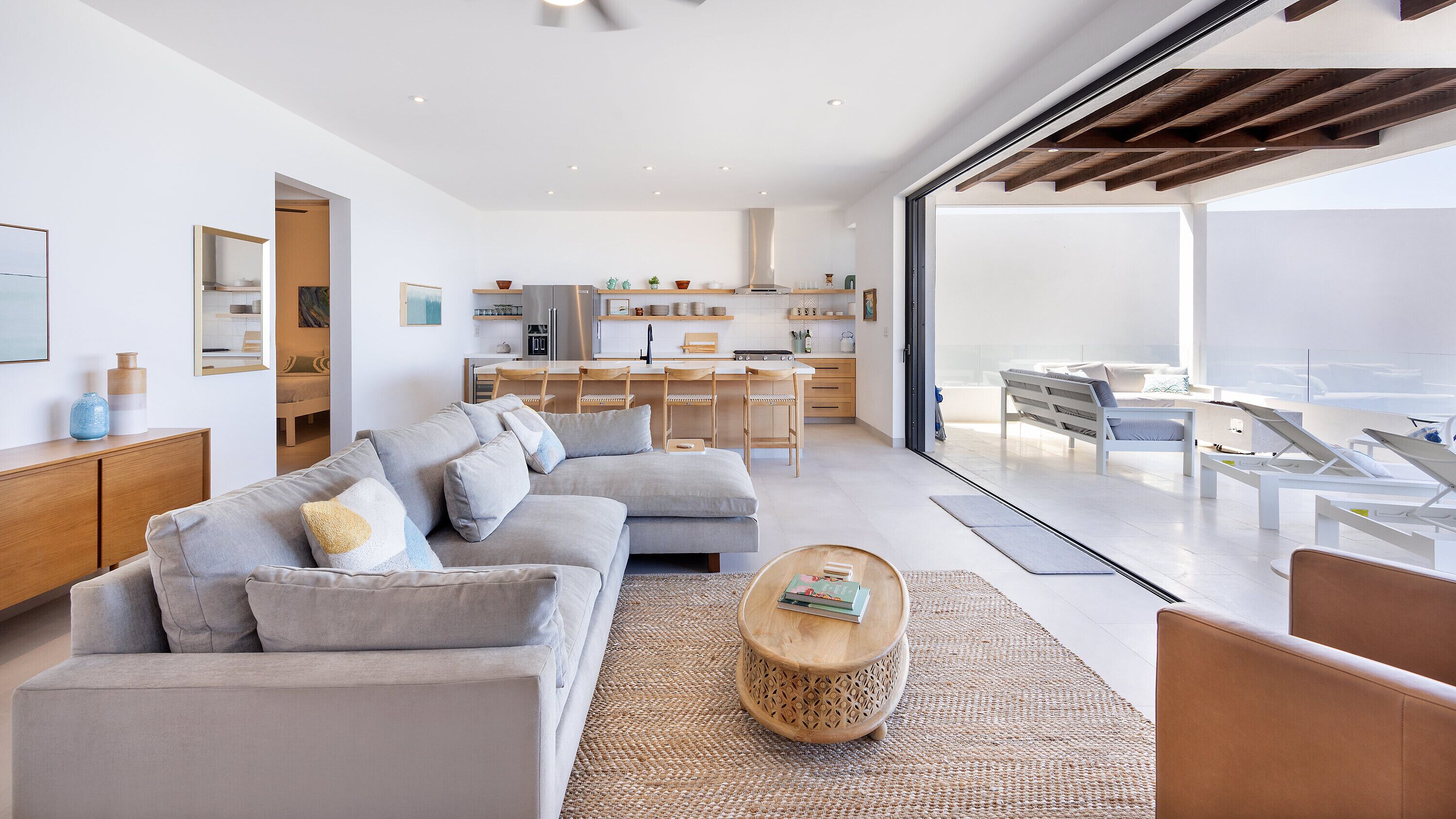 A modern living room with a sofa, coffee table, and a view of the balcony.