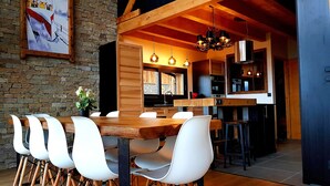 A modern kitchen with wooden beams, white chairs, and a dining table. - Chalet Louma Font-romeu Vue Panoramique Style Contemporain. 10 Couchages (Font-Romeu-Odeillo-Via)