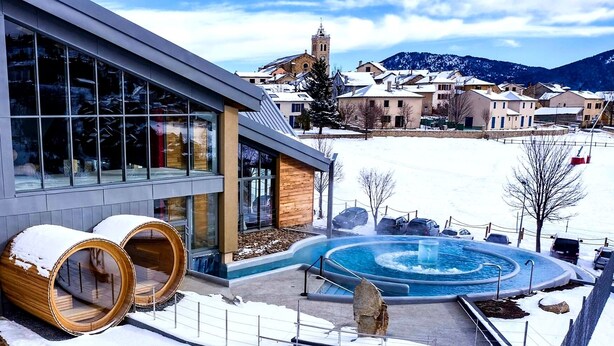 A modern building with large windows, a hot tub, and a snowy landscape with a mountain in the background. - Chalet Louma Font-romeu Vue Panoramique Style Contemporain. 10 Couchages (Font-Romeu-Odeillo-Via)