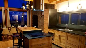 A modern kitchen with wooden cabinets, a black countertop, and a built-in stove. - Chalet Louma Font-romeu Vue Panoramique Style Contemporain. 10 Couchages (Font-Romeu-Odeillo-Via)