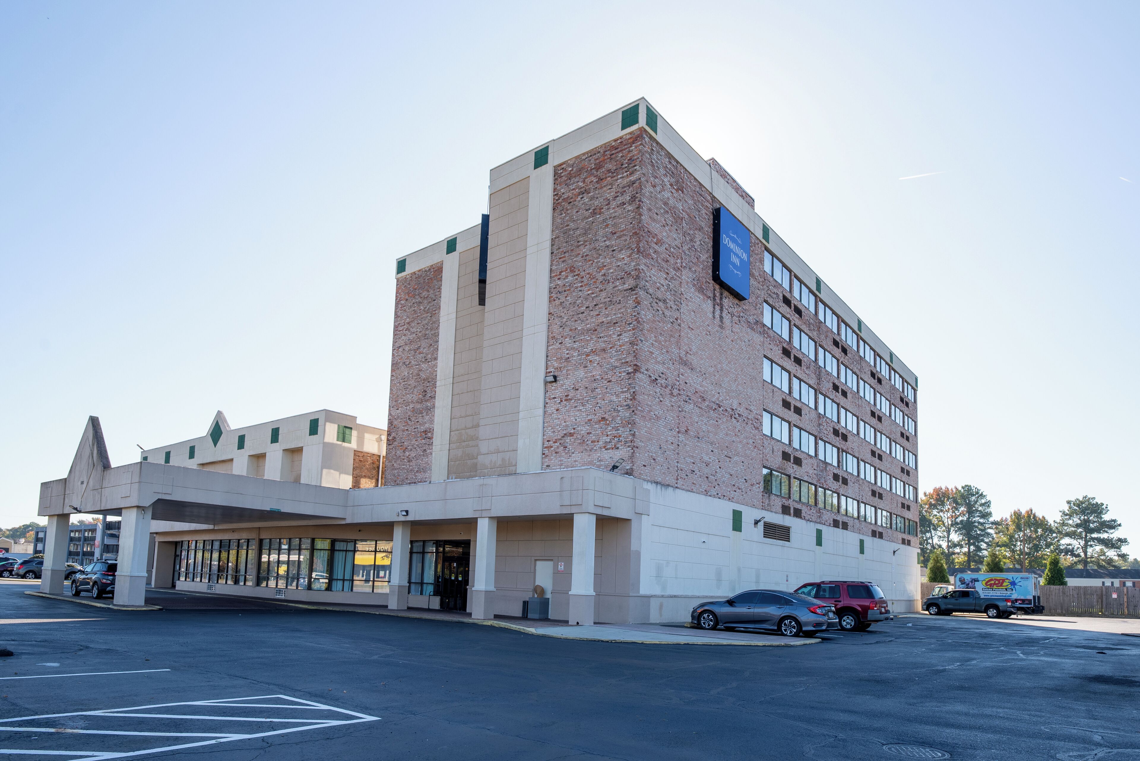 Un hotel de varios pisos con fachada de ladrillo y techo plano.