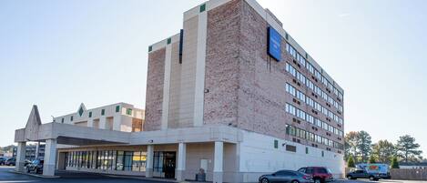Un hotel de varios pisos con fachada de ladrillo y techo plano.