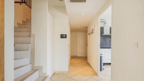 A modern interior with a staircase leading to a kitchen area. - Villa Spacieuse Avec Piscine Proche de la Promenade Des Anglais (Nice)