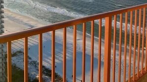 Un balcón con vista al océano y a la playa.