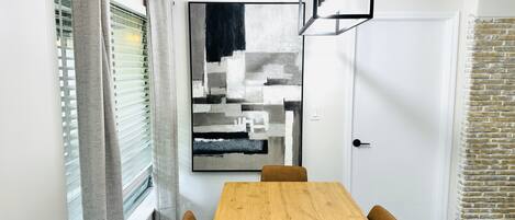 Un comedor con una mesa de madera, un cuenco y sillas.