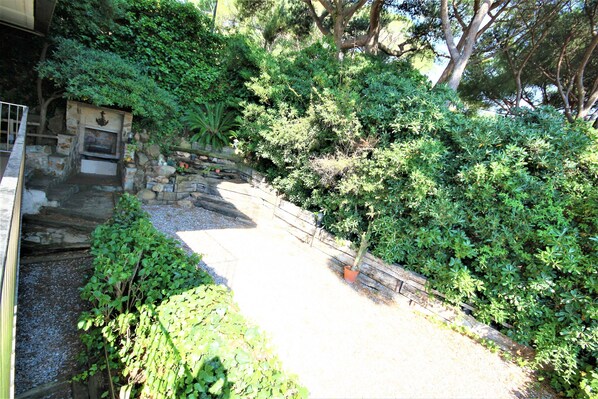 Stroll through this serene garden, surrounded by lush greenery and a charming stone structure.
