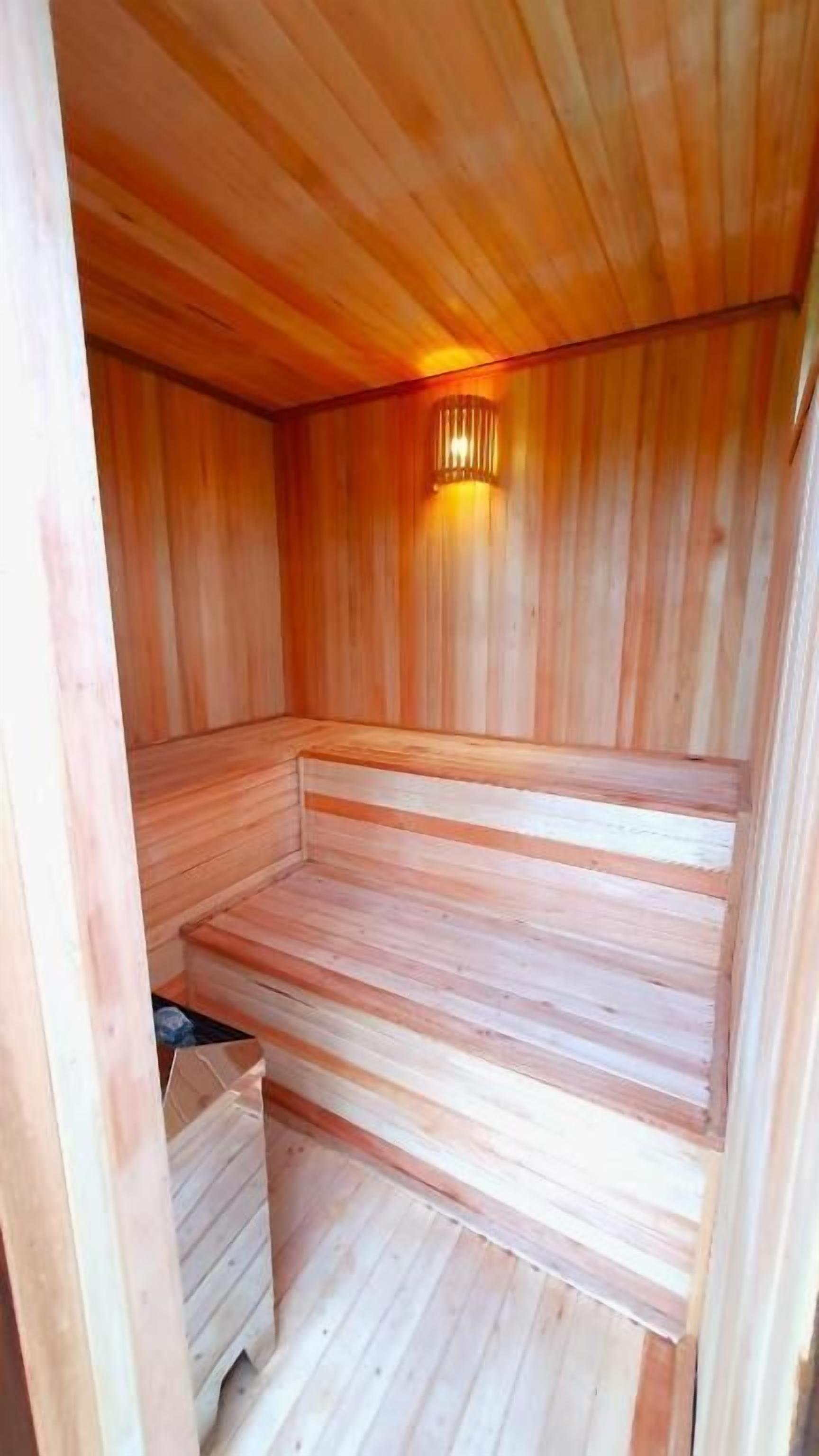 Een sauna met houten wanden en een bank.