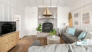 A living room with a fireplace, a television, and a sofa. - Carpinteria Beach Front Bungalow  (Carpinteria)