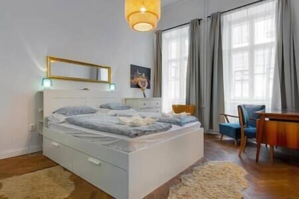 A bedroom with a bed, a desk, and a chair.