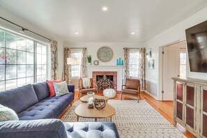 Una sala de estar con sofá, sillones, chimenea y televisión.