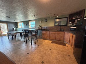 Una cocina con una isla central, armarios de madera y un refrigerador negro.