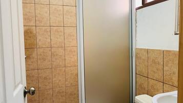 Chuveiro, toalhas de banho, sabonete, shampoo