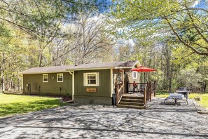 A cabin with a porch, a table with an umbrella, and a grill. - Cozy Ski Retreat on UTV/Snowmobile Trail (Merrillan)