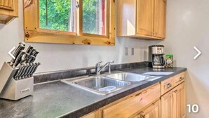 Una cucina con mobili in legno, un lavello doppio e una macchina da caffè.