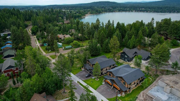 A residential area with houses, a lake, and a forested landscape. - Whitefish Lynx Run Town House Private Hot Tub (Whitefish)