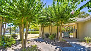 Un sendero bordeado de árboles que conduce a un edificio con un letrero que indica piscina privada.
