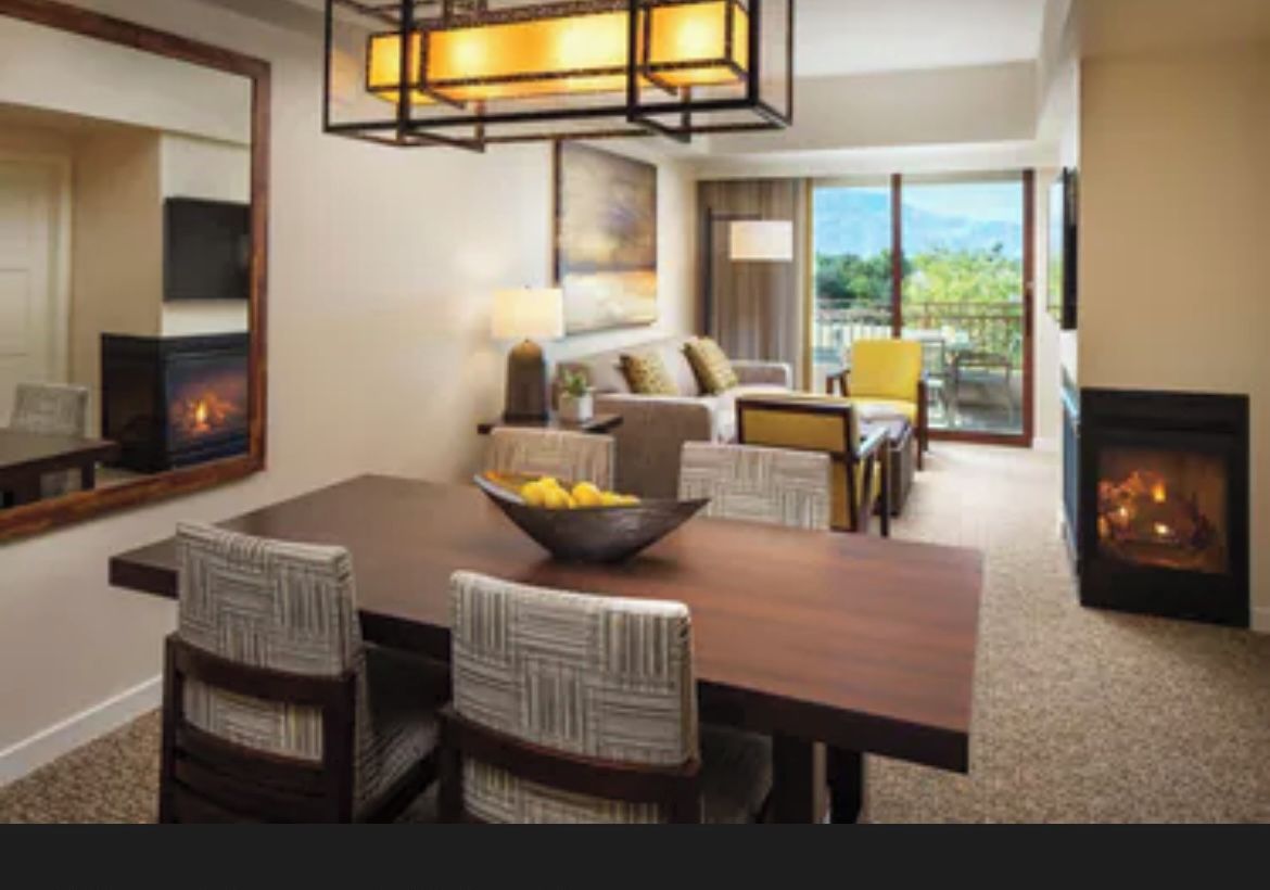 Salón y comedor de una villa con chimenea, mesa de comedor, sillas y sofá.