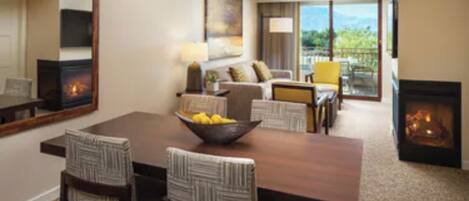 Salón y comedor de una villa con chimenea, mesa de comedor, sillas y sofá.