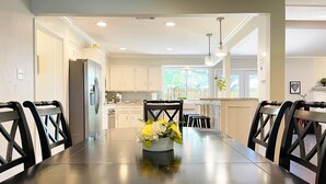 A dining area with a long table, black chairs, and a vase of flowers. - Pet-friendly 4-bedroom PLUS Office and Hot Tub (Dallas)