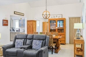 Ein modernes Wohnzimmer mit Ledersofa, Esstisch und Holzschränken.