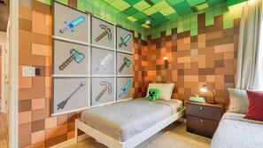 A bedroom with a bed, a nightstand, a wall-mounted shelf with pixel art, and a green plush toy. - Ever After by Avantstay Pop Culture Design, Pool (Davenport)