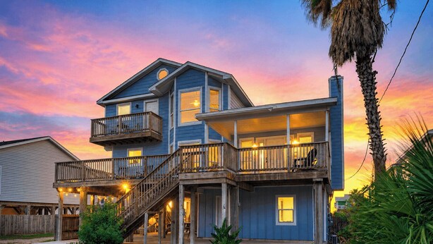 A two-story house with a balcony, a staircase, and a porch. - Private Pool, Game Room, Patio, Near the Beach Palm House by Avantstay (Port Aransas)