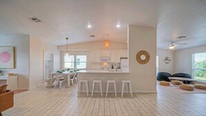 A spacious living area with a kitchen, dining table, and seating. - Near the Beach w/ Pool, Boat Parking Golf Cart Zone Agave House by Avantstay (Port Aransas)