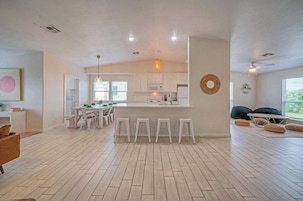 A spacious living area with a kitchen, dining table, and seating.
