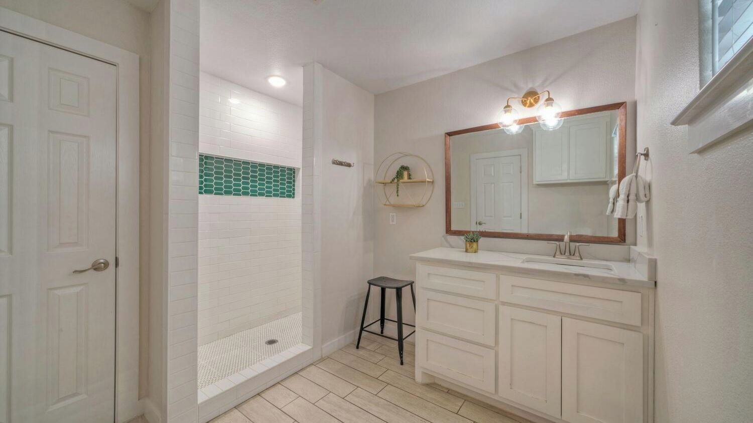 A bathroom with a shower, a vanity with a mirror, and a toilet.