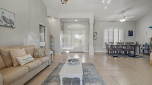 A spacious living room with a sofa, coffee table, and dining area.
