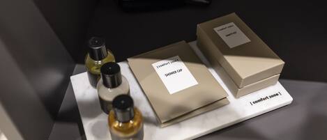 A display of toiletries including a shower cap, a bottle of liquid, and a box labeled "Comfort Zone."