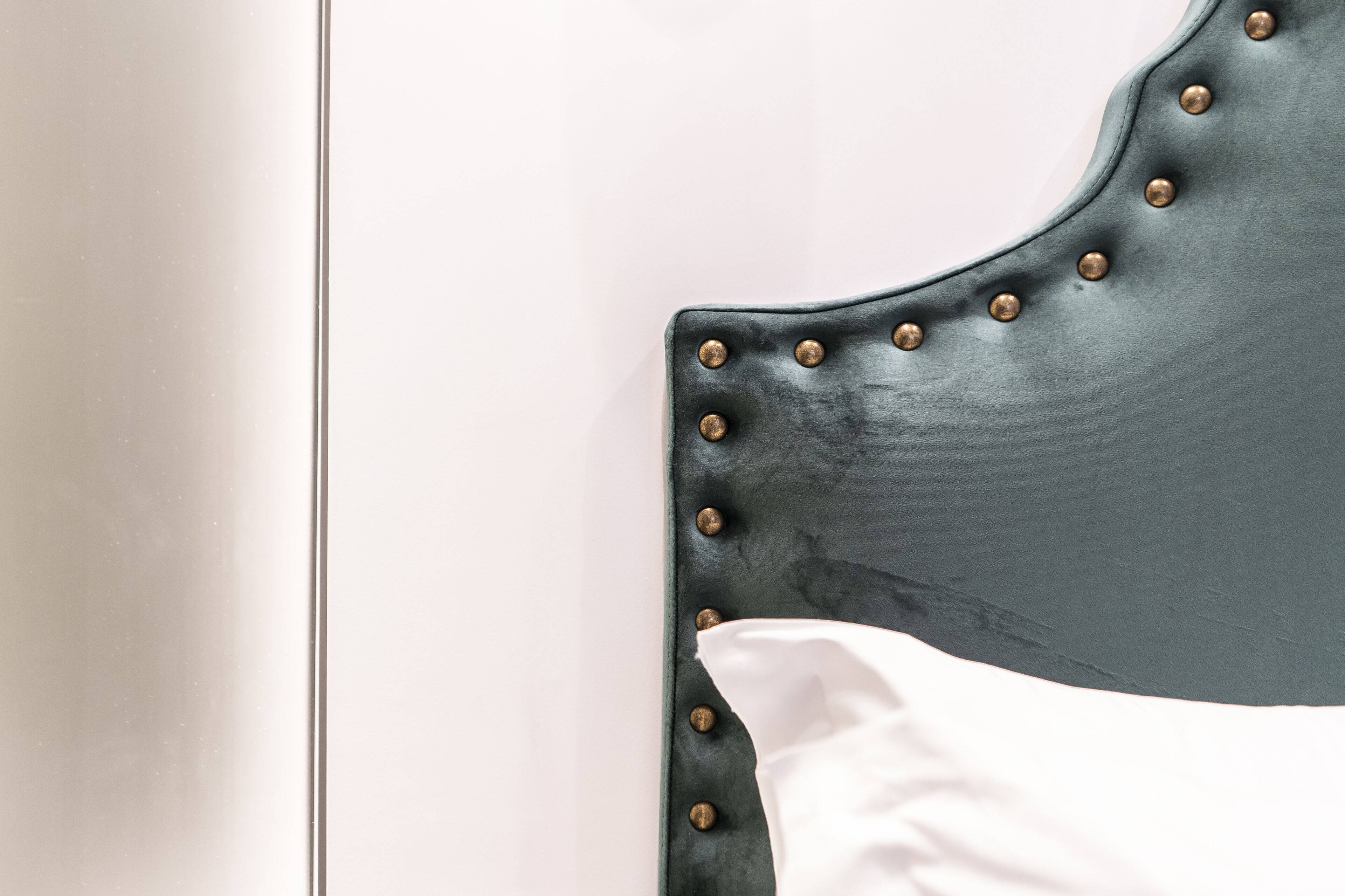 A close-up of a chair with a dark, metallic headrest and riveted details.