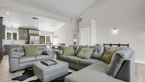 A modern living room with a grey sofa set, a coffee table, and a black and white rug.