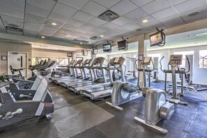 A gym with multiple treadmills, ellipticals, and weight machines.