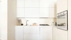 A compact kitchen with white cabinets, a sink, and a stove. - Enchanting flat, in the core of Treviso, the city of Prosecco, pet friendly (Treviso)