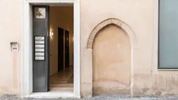 An entrance with a door, a small sign, and an arched window. - Enchanting flat, in the core of Treviso, the city of Prosecco, pet friendly (Treviso)