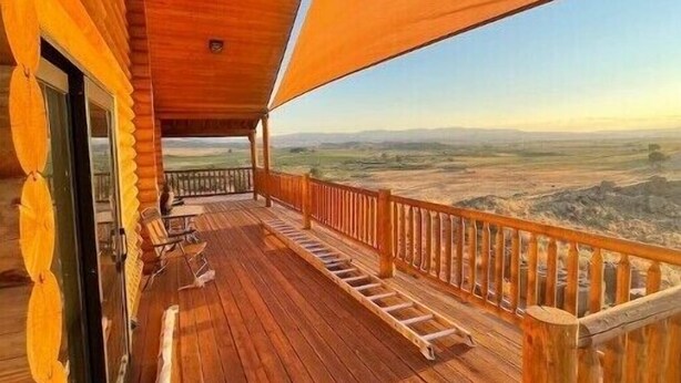 Een houten terras met uitzicht op het landschap.