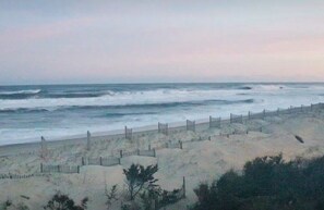 A beach with a wooden fence and sandy dunes.