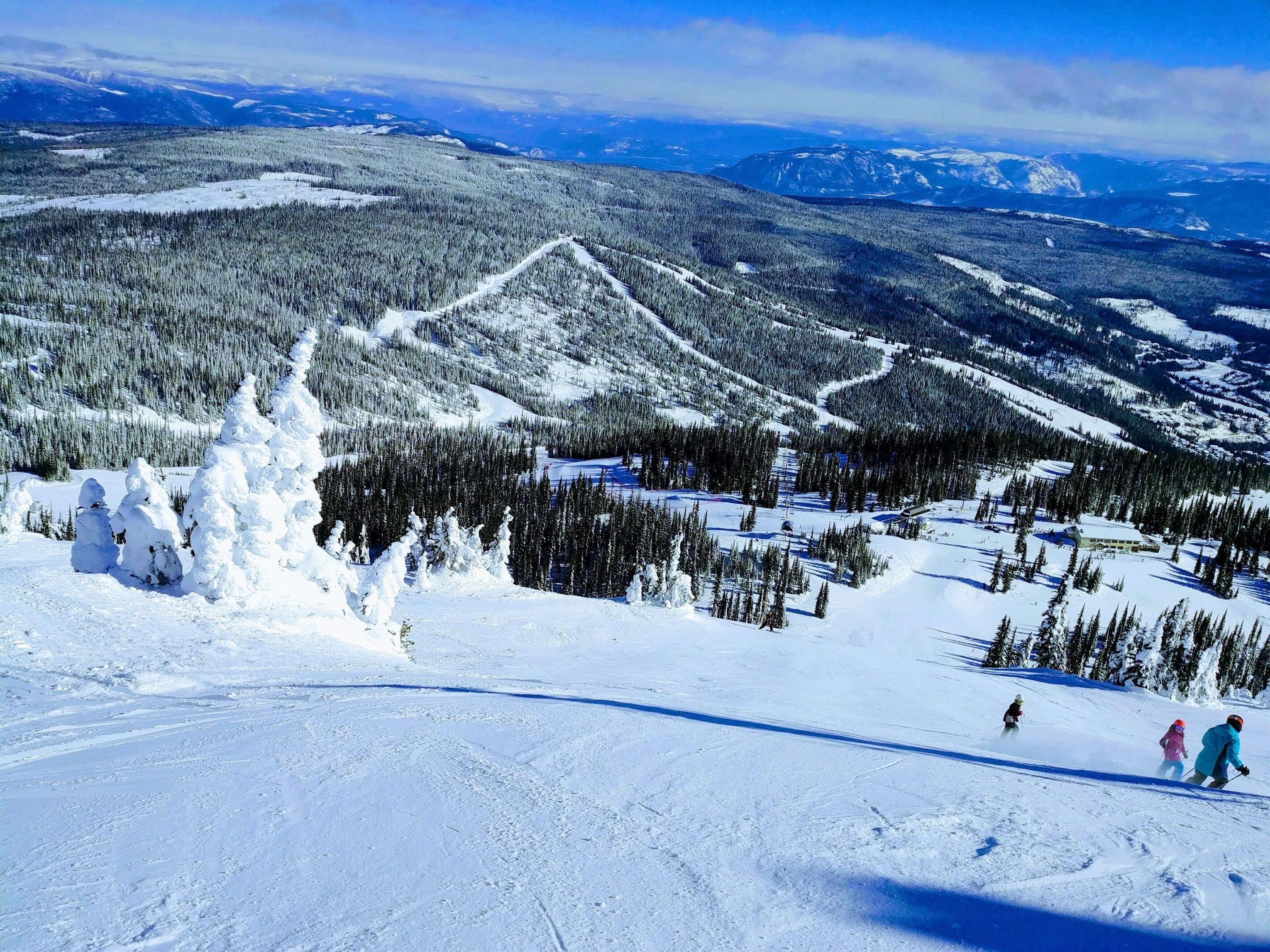 A snowy mountain landscape with ski trails and a lodge.