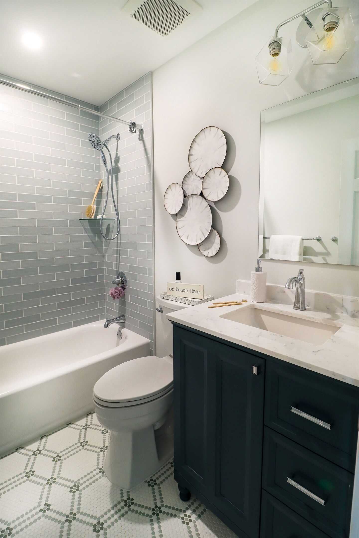 Un baño con bañera, inodoro y tocador con lavabo.